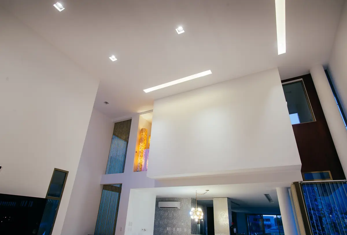 interior moderno de doble altura con escaleras y vidrios de colores — proyecto Grand Bell 60, por Mercedes  klappenbach, en City Bell