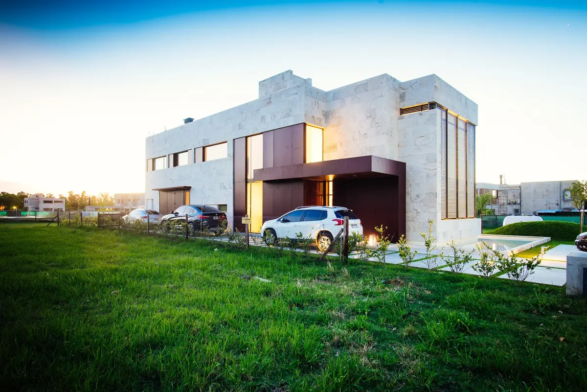 Casa moderna de concreto com grandes janelas e gramado — projeto Grand Bell 60, por Mercedes  klappenbach, em City Bell