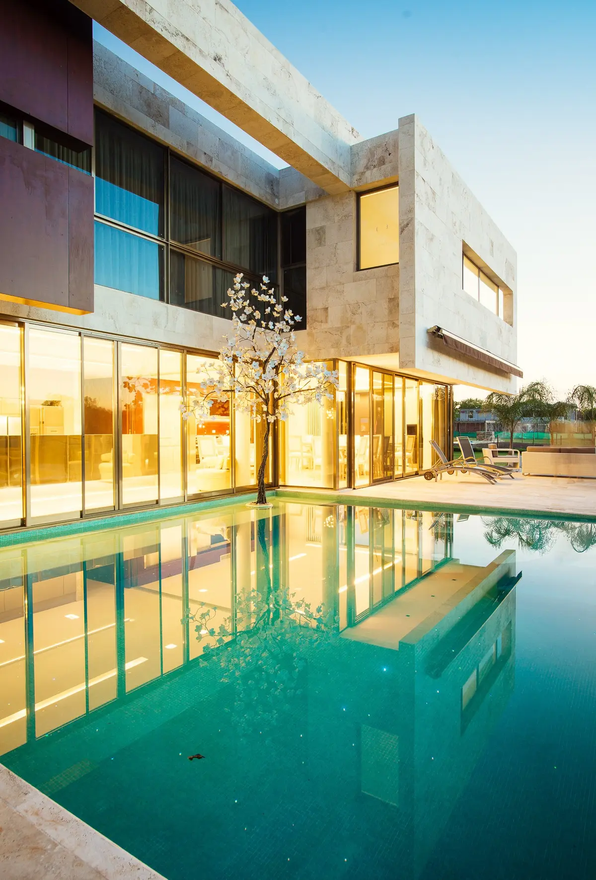 Fachada moderna com piscina e iluminação quente — projeto Grand Bell 60, por Mercedes  klappenbach, em City Bell