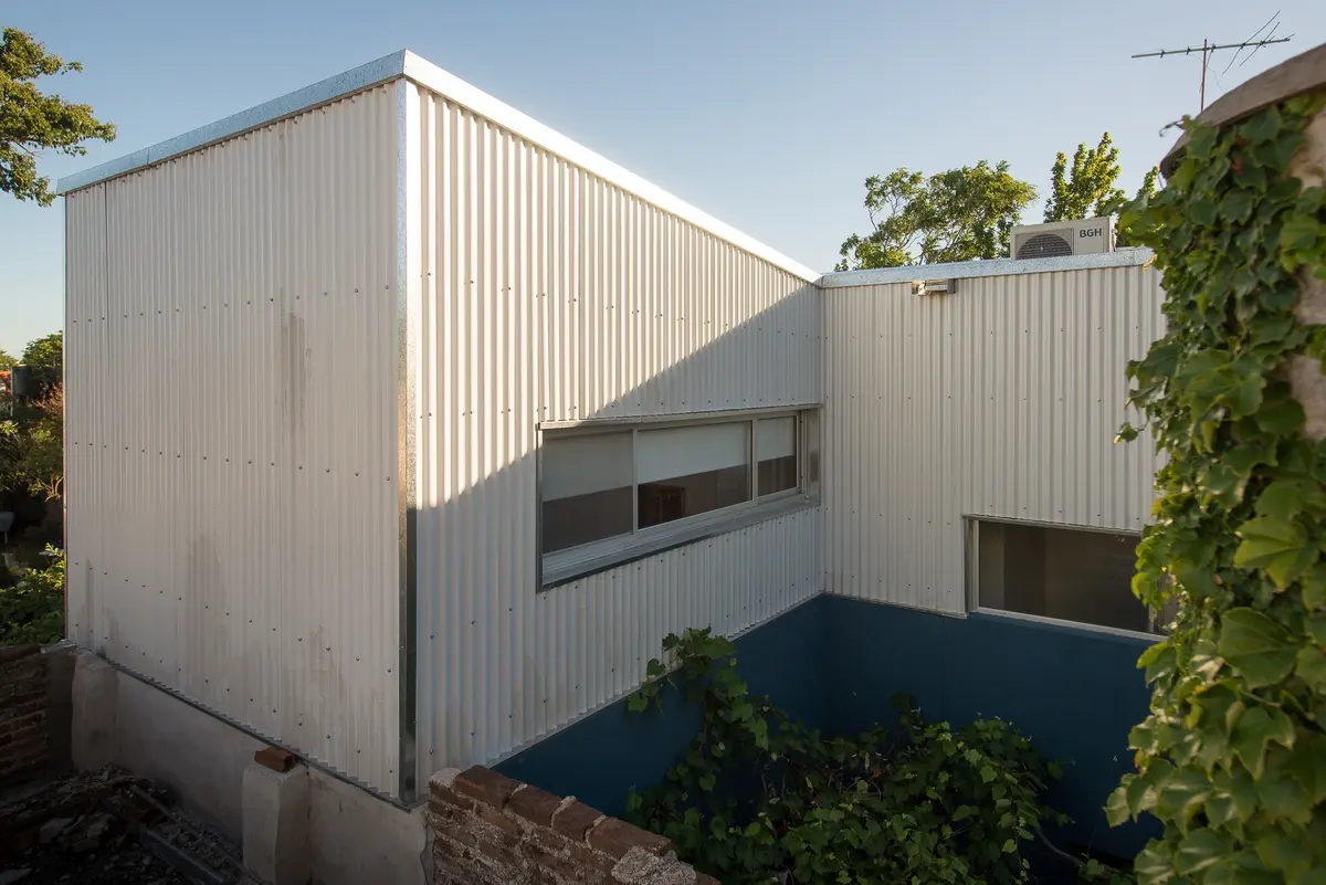 fachada moderna de metal corrugado branco — projeto Calle 67, por Mercedes  klappenbach, em La Plata