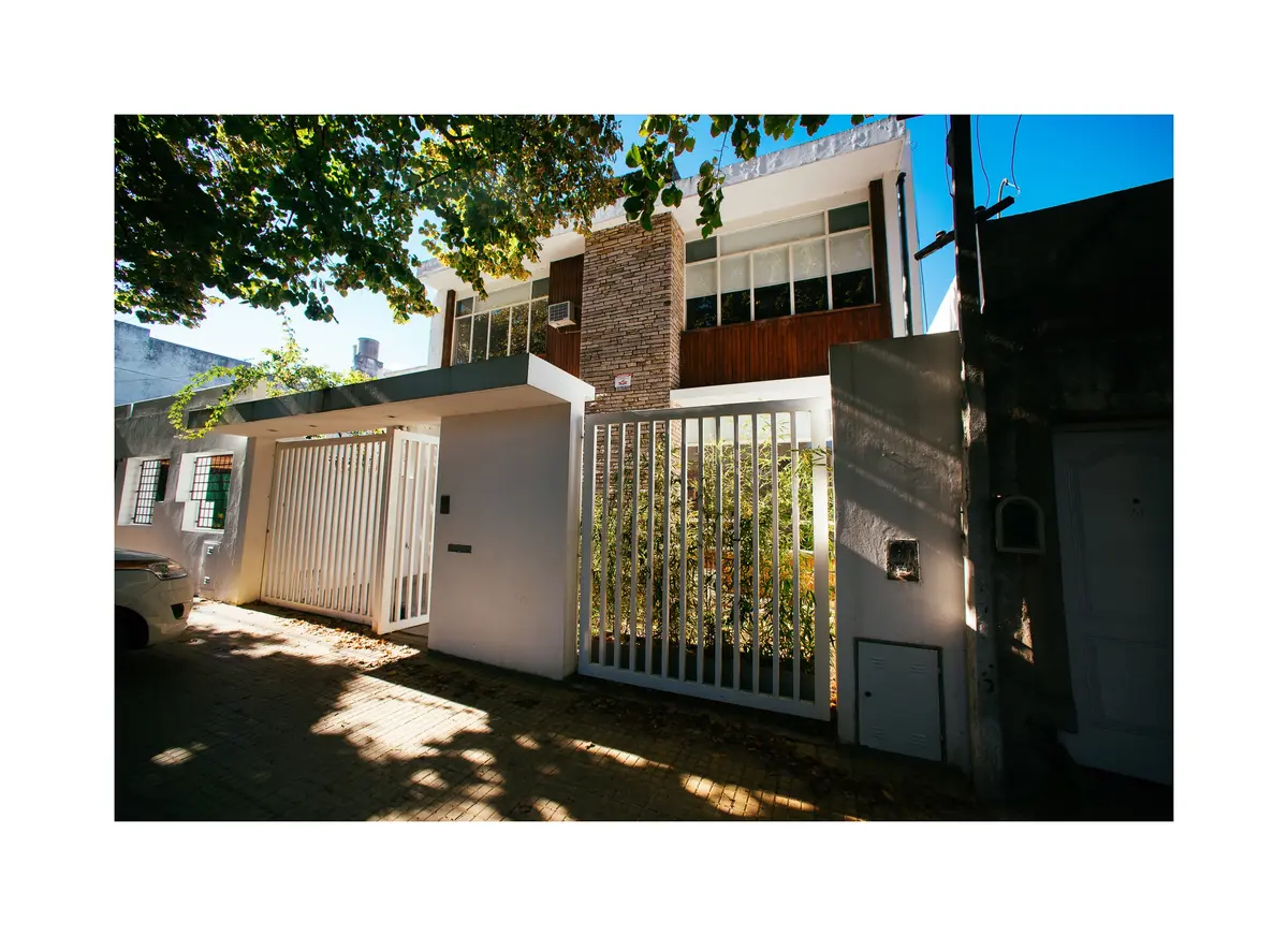 Fachada geométrica moderna com portão de metal e concreto — projeto Calle 116, por Mercedes  klappenbach, em La Plata