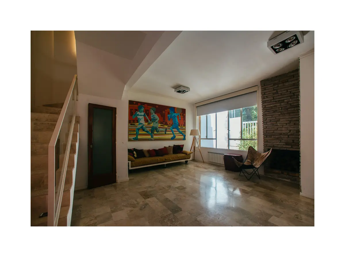 Sala de estar moderna com mural colorido e lareira de tijolos — projeto Calle 116, por Mercedes  klappenbach, em La Plata