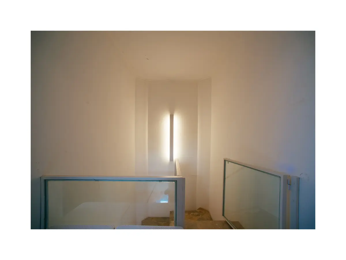 corredor minimalista com iluminacao vertical e divisórias de vidro — projeto Calle 116, por Mercedes  klappenbach, em La Plata