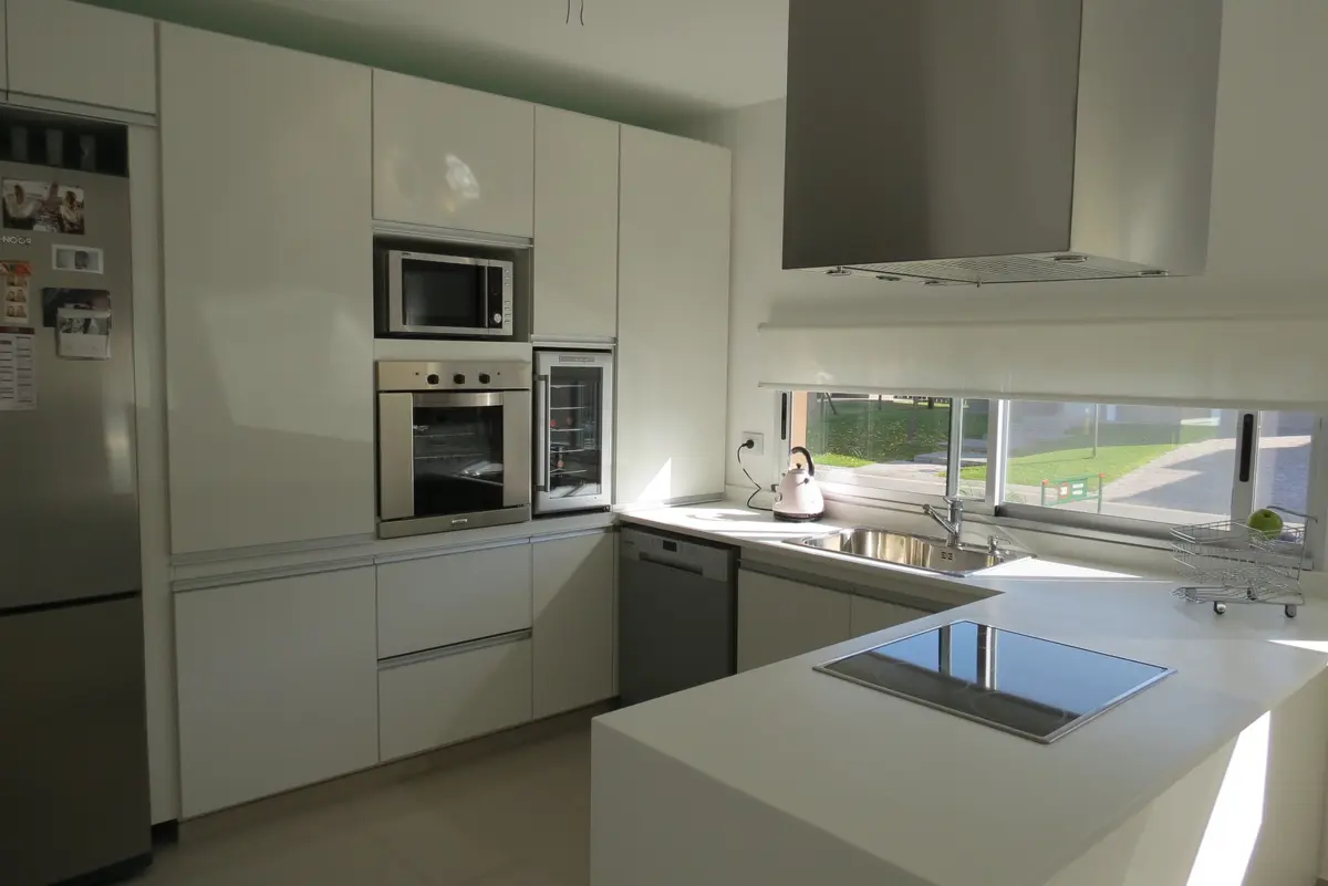 cozinha moderna branca com armários embutidos e janela grande — projeto Ampliación y refacción  San Agustín, por Olivieri Arquitectura, em Tigre