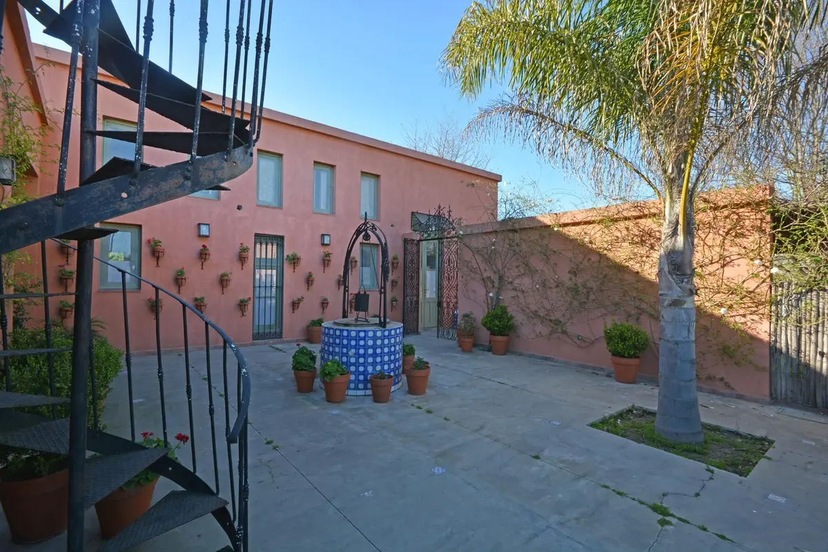Patio mediterráneo con fuente y escalera caracol — proyecto Casa 14, por Estudio Martínez Nespral