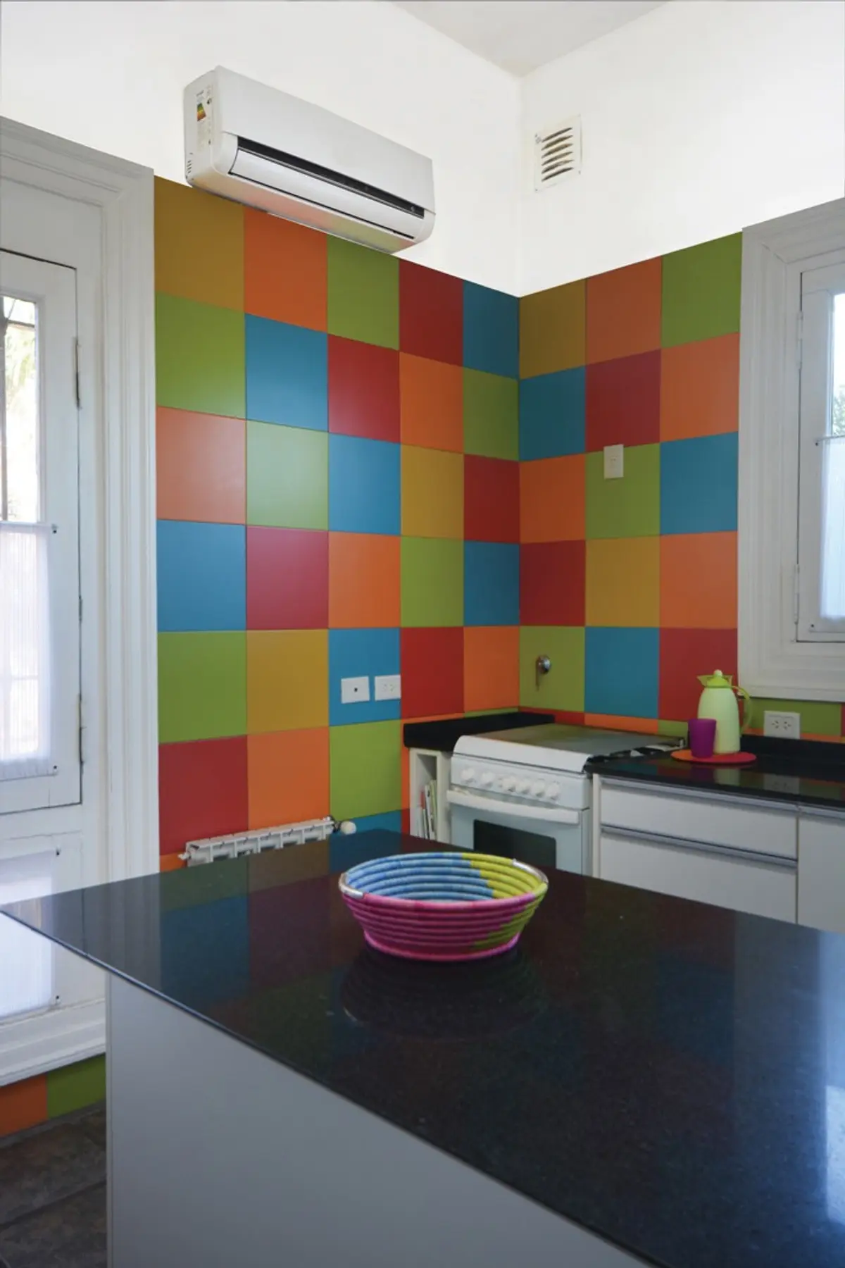 Cozinha moderna com parede de azulejos coloridos e detalhes vibrantes — projeto Casa 14, por Estudio Martínez Nespral