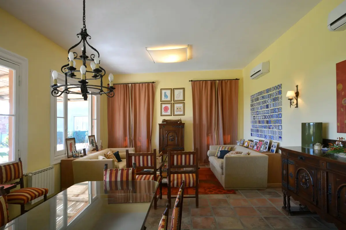 Sala de estar-comedor mediterrânea com móveis de tecido bege e detalhes clássicos — projeto Casa 14, por Estudio Martínez Nespral