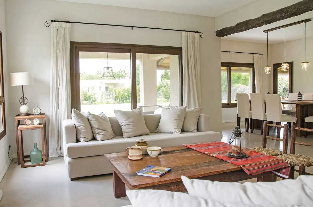 Living moderno con vigas de madera y grandes ventanales al campo — proyecto Casa 13, por Estudio Martínez Nespral