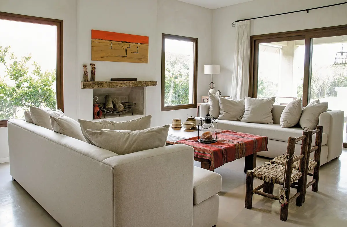 Sala de estar moderna de estilo mediterráneo con amplios ventanales y sofás grandes — projeto Casa 13, por Estudio Martínez Nespral