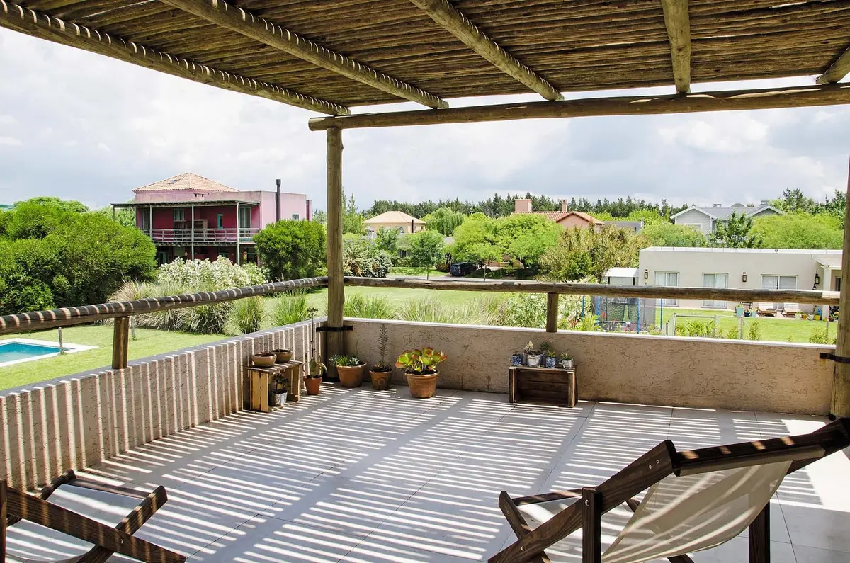 Terraço rústico de madeira com pérgola e vista rural — projeto Casa 13, por Estudio Martínez Nespral