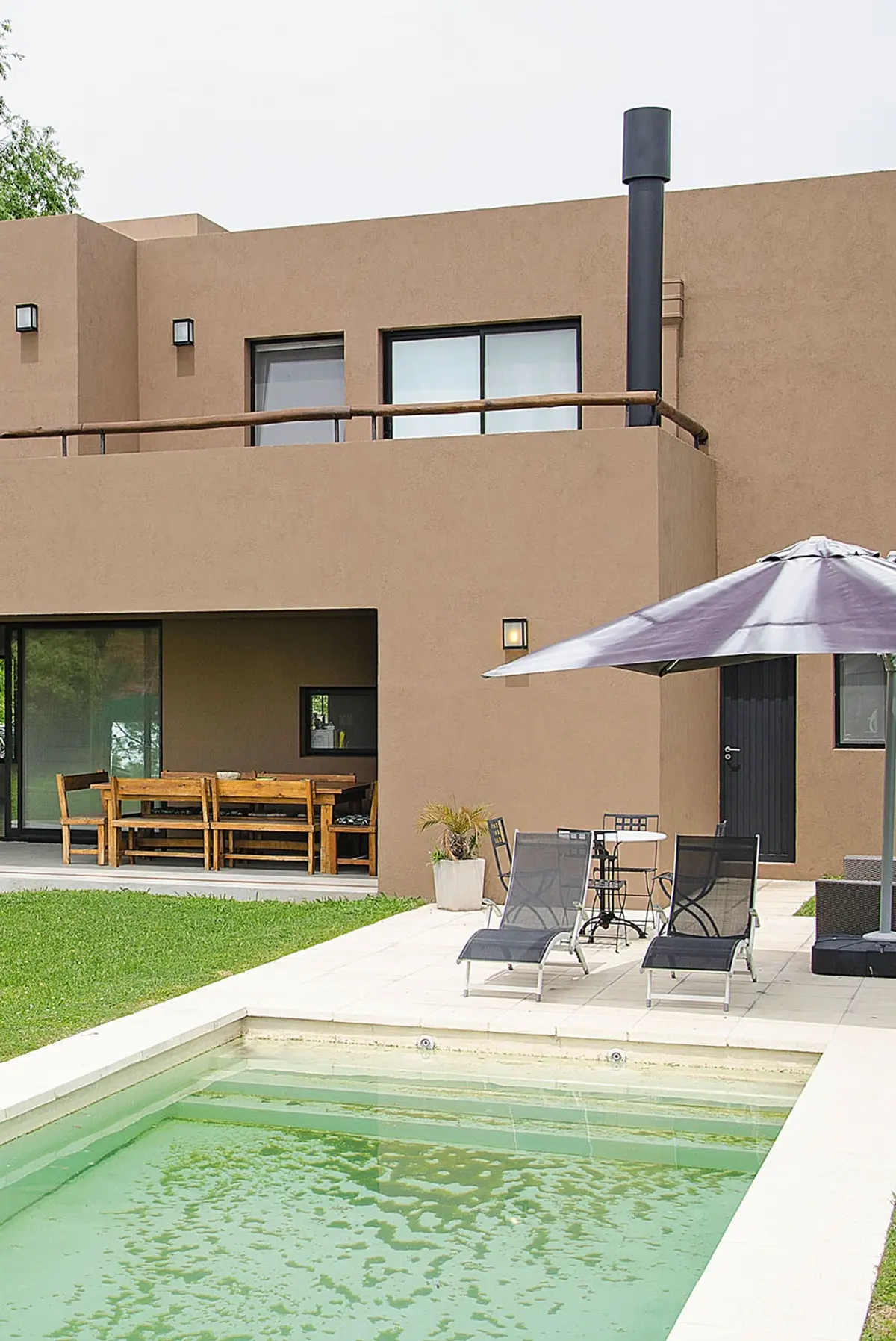 Área de piscina moderna estilo mediterráneo con sala de estar y comedor exterior — projeto Casa 12, por Estudio Martínez Nespral