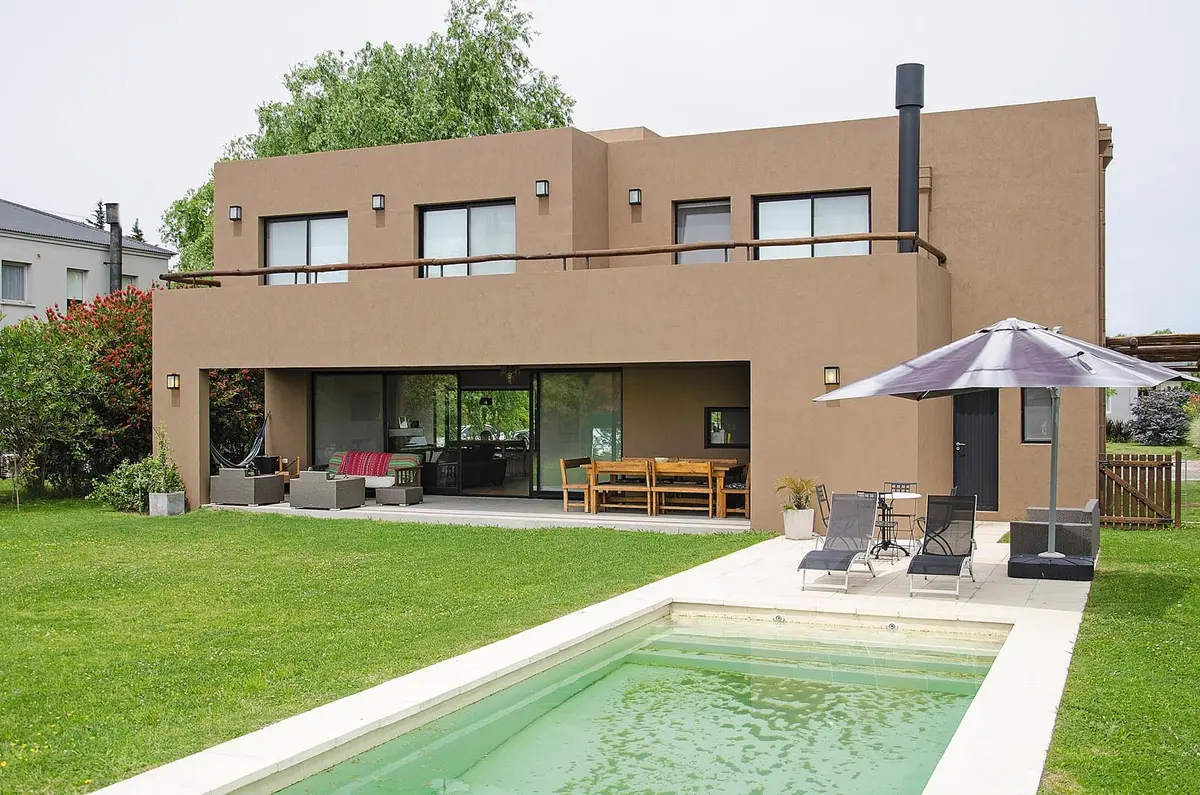 Fachada moderna com piscina e área externa de concreto e madeira — projeto Casa 12, por Estudio Martínez Nespral