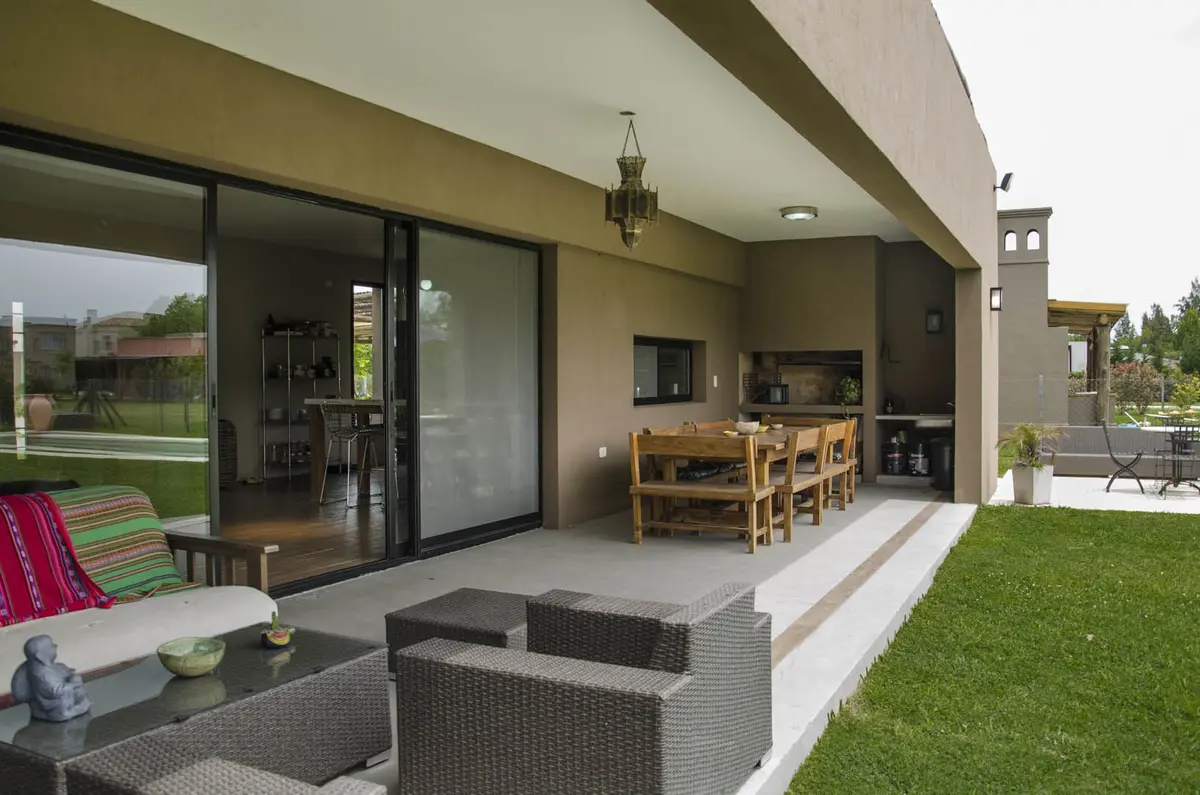 Pátio moderno com pérgola de madeira e móveis externos — projeto Casa 12, por Estudio Martínez Nespral