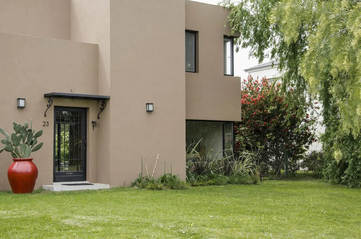 fachada moderna con jardín frondoso — proyecto Casa 12, por Estudio Martínez Nespral
