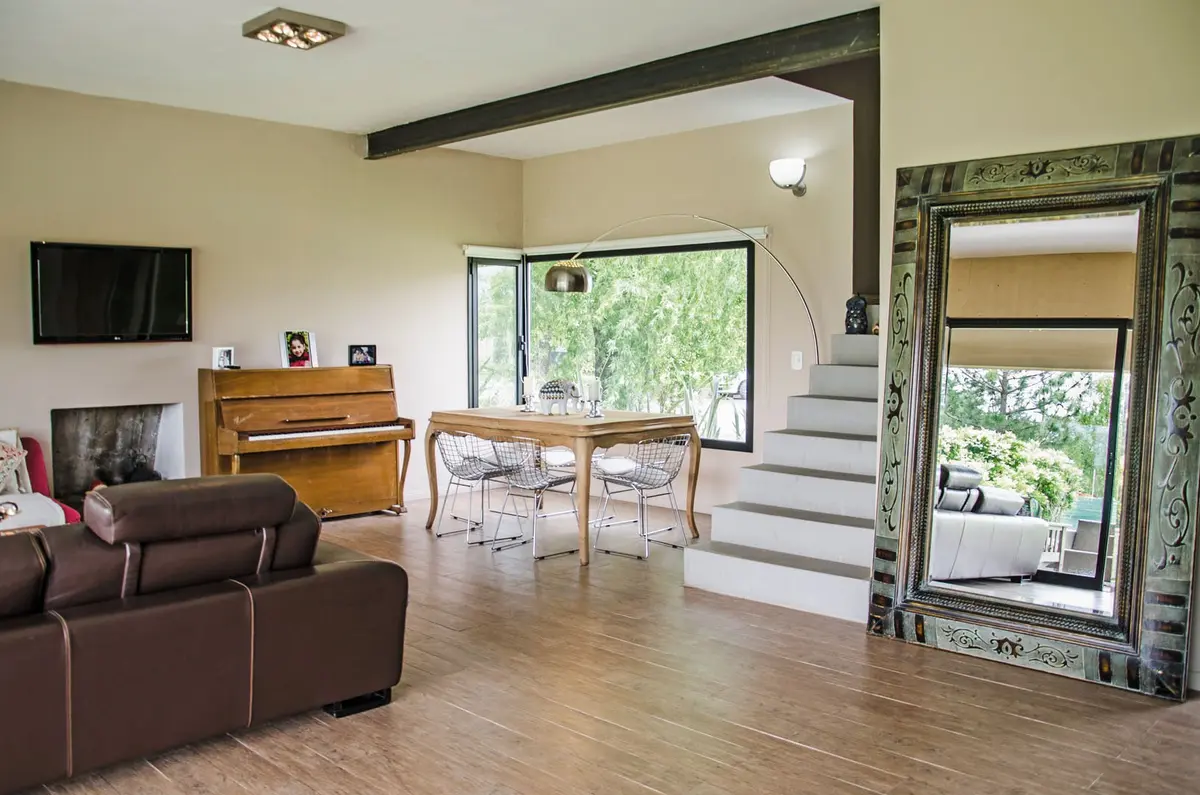 Sala de estar e jantar com vigas expostas e piano — projeto Casa 12, por Estudio Martínez Nespral