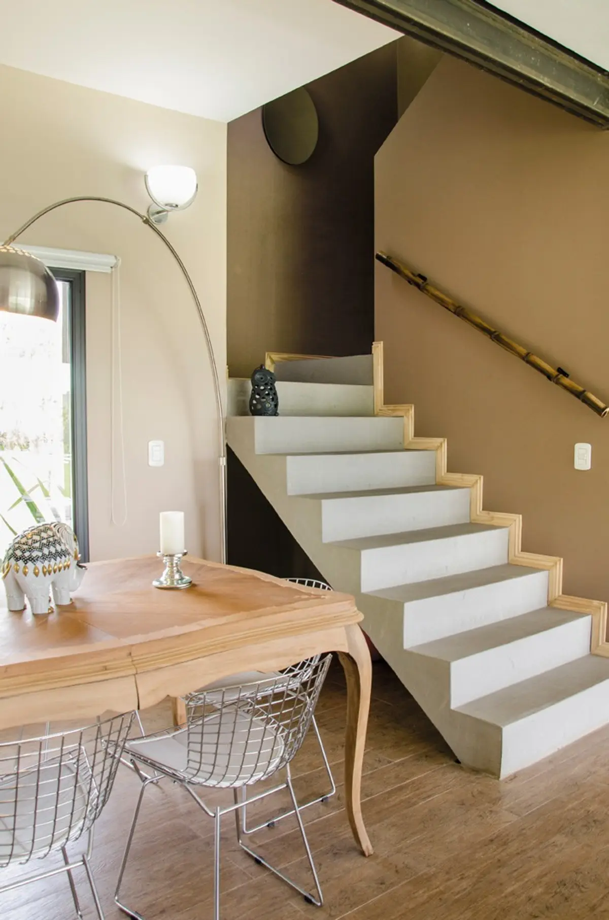 Sala de jantar moderna com escada flutuante e luminária de piso em arco — projeto Casa 12, por Estudio Martínez Nespral