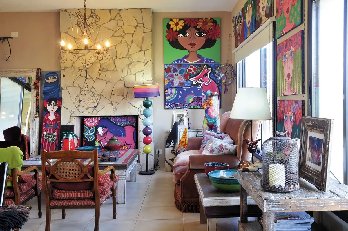 Sala bohemia con chimenea de piedra y obras de arte coloridas — proyecto Casa 9, por Estudio Martínez Nespral