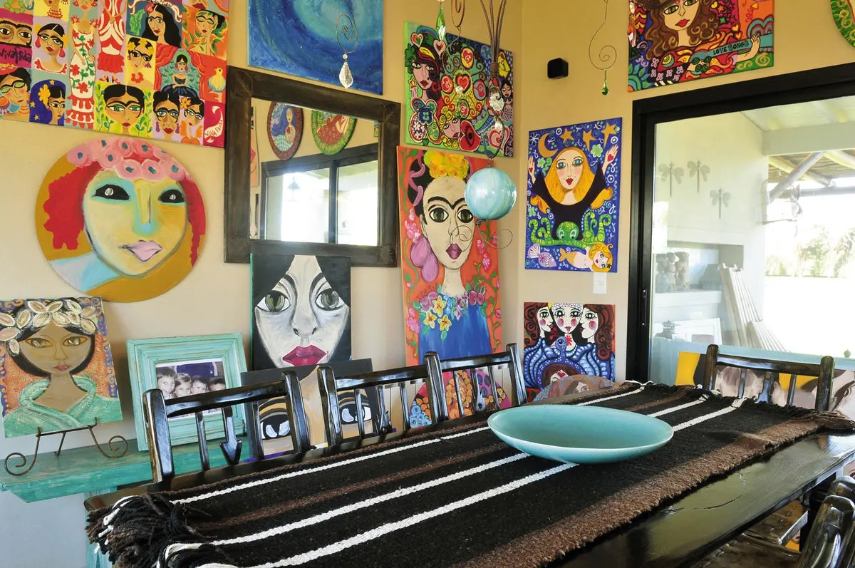 Comedor bohemio con arte colorido y mesa de madera — proyecto Casa 9, por Estudio Martínez Nespral