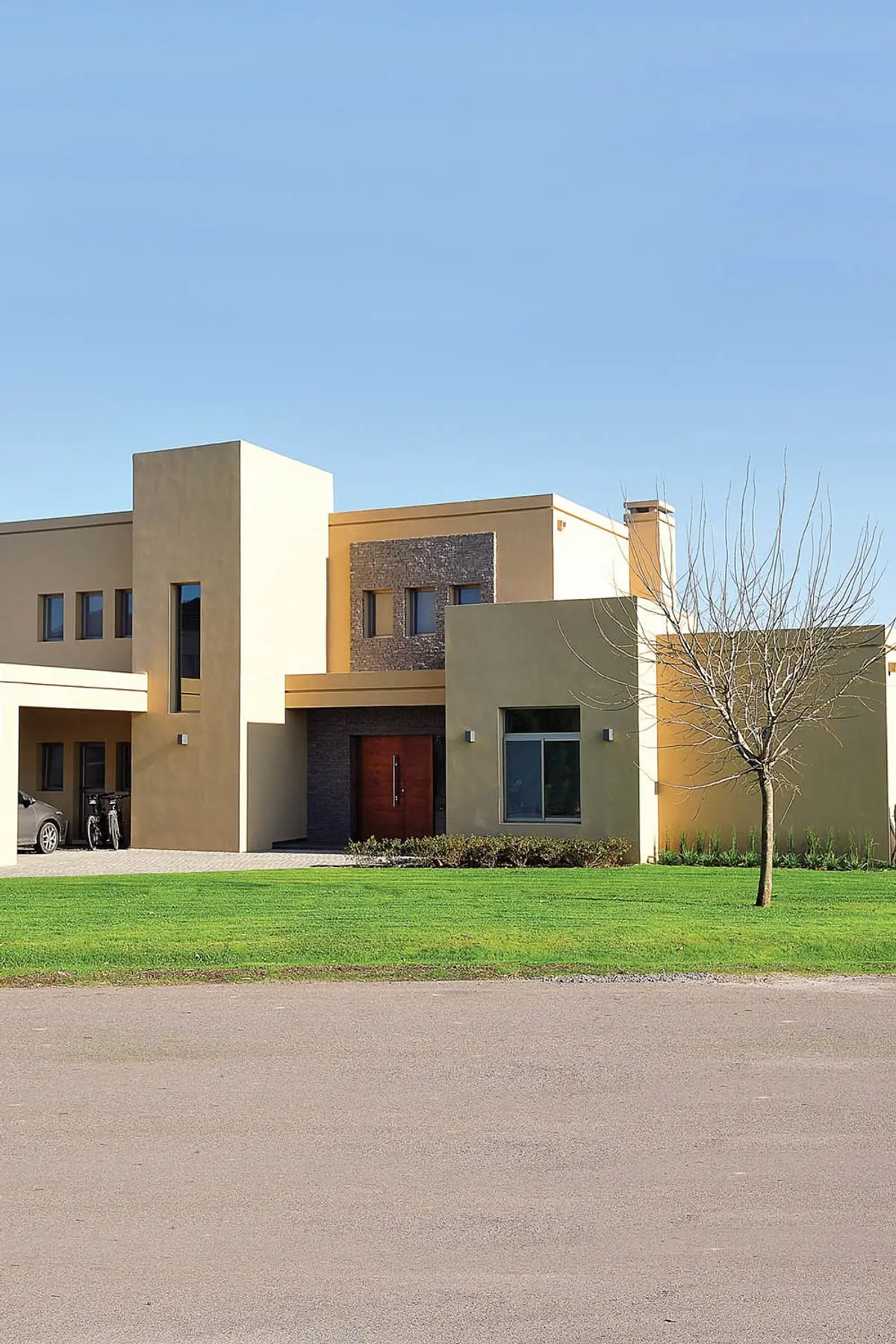 Fachada moderna de casa com volumes geométricos e revestimento em pedra — projeto Casa 8, por Estudio Martínez Nespral