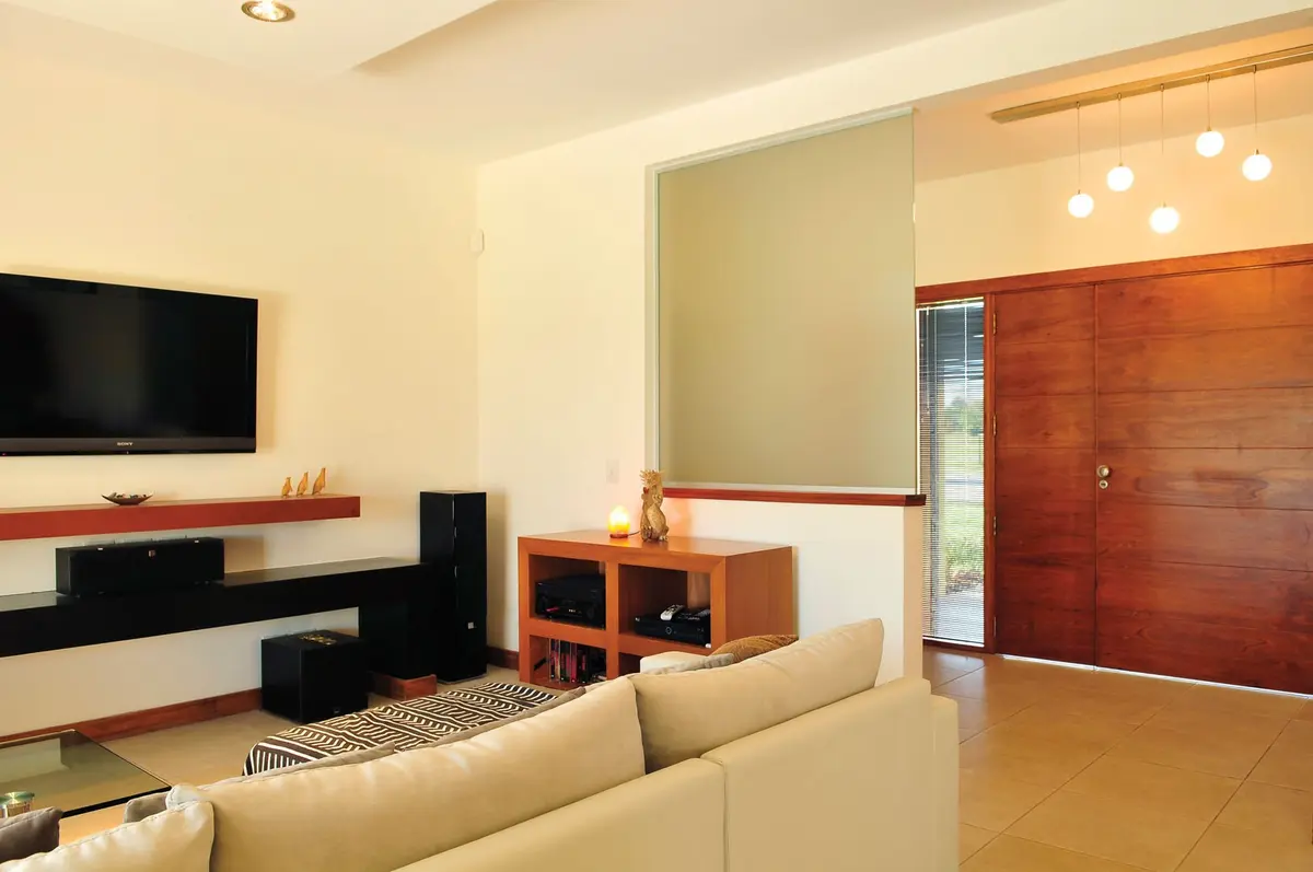Living moderno con sofá modular y puerta corrediza de madera — proyecto Casa 8, por Estudio Martínez Nespral