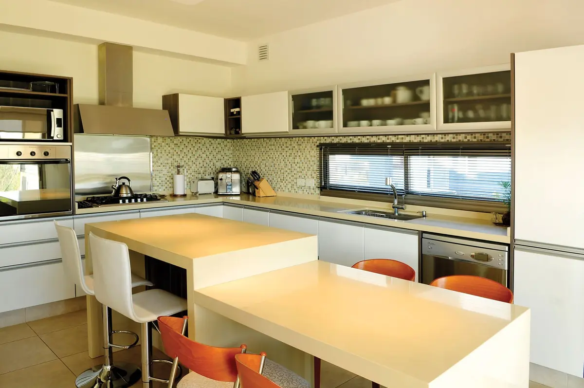 Cozinha moderna e clara com ilha, sala de jantar integrada, estilo escandinavo — projeto Casa 8, por Estudio Martínez Nespral
