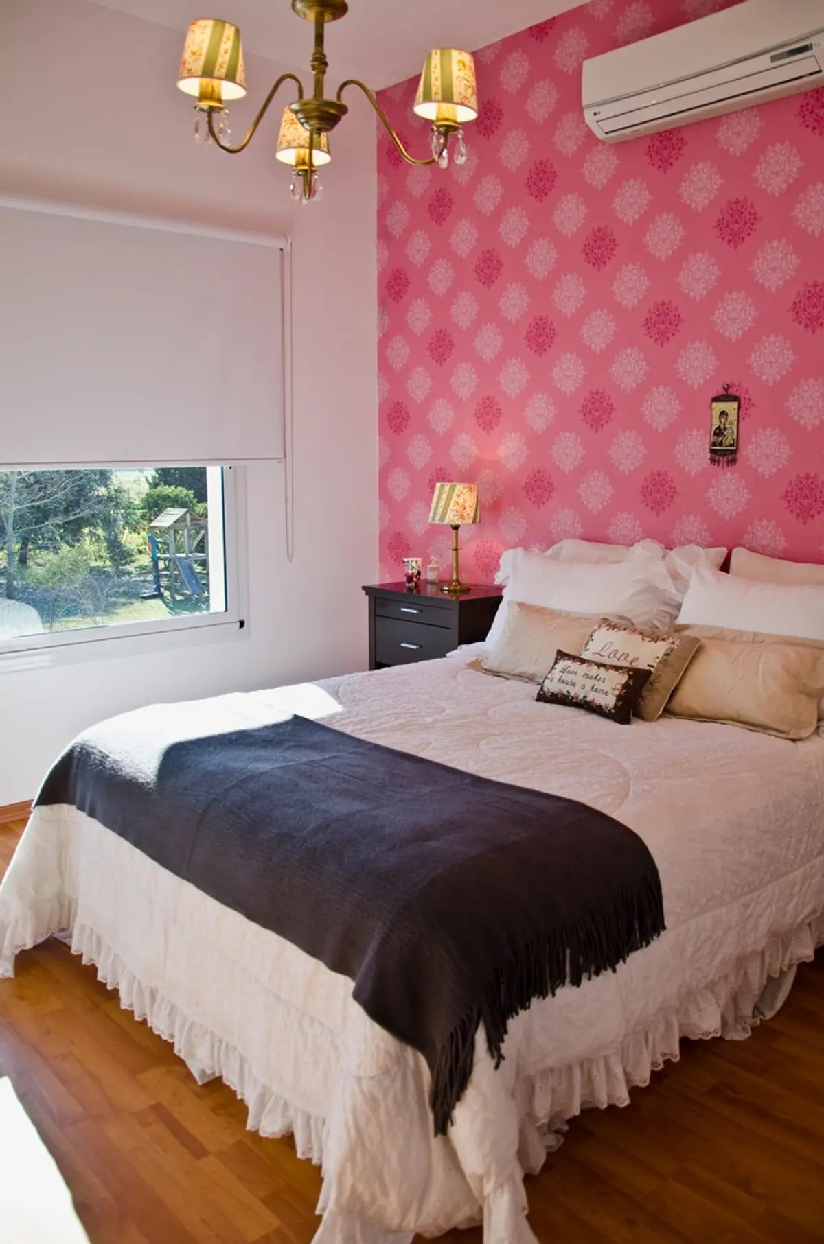 Quarto rosa com papel de parede floral e cama com babados — projeto Casa 7, por Estudio Martínez Nespral