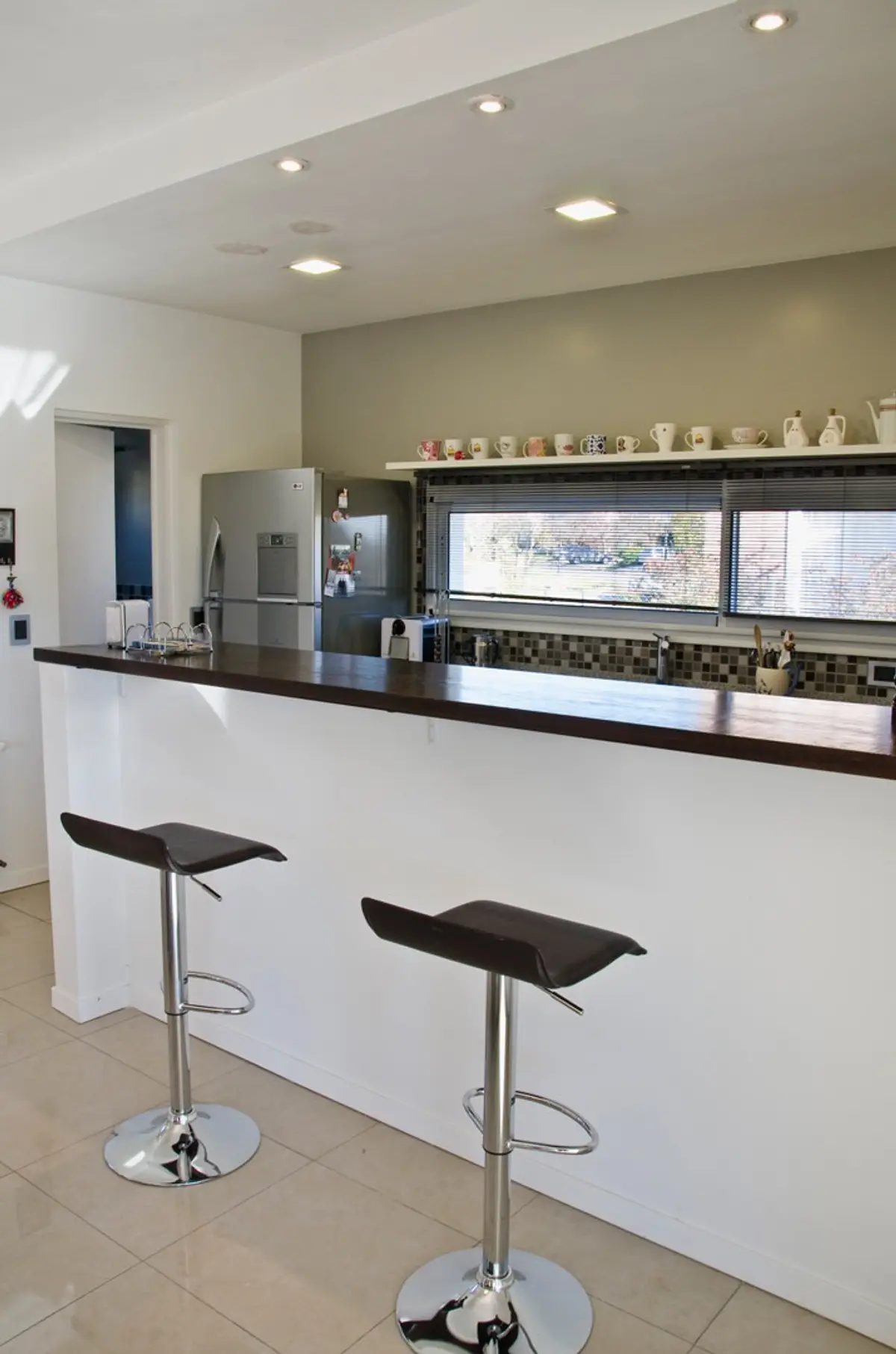 Cozinha moderna com balcão, bancada de madeira escura e janelas grandes — projeto Casa 7, por Estudio Martínez Nespral
