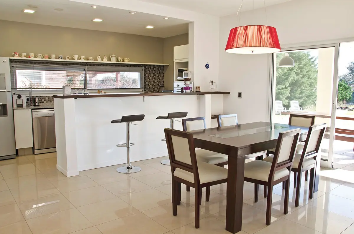 Cozinha e sala de jantar modernas integradas com ilha e luz vermelha — projeto Casa 7, por Estudio Martínez Nespral