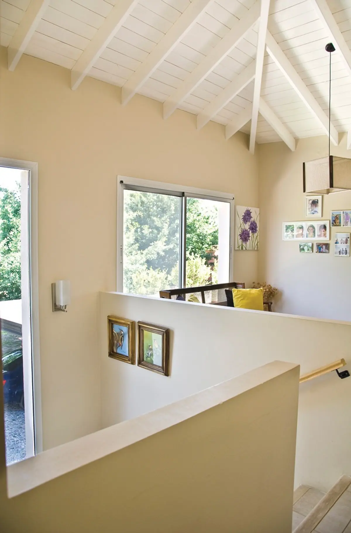 Corredor e escada moderno com teto de vigas e arte — projeto Casa 6, por Estudio Martínez Nespral
