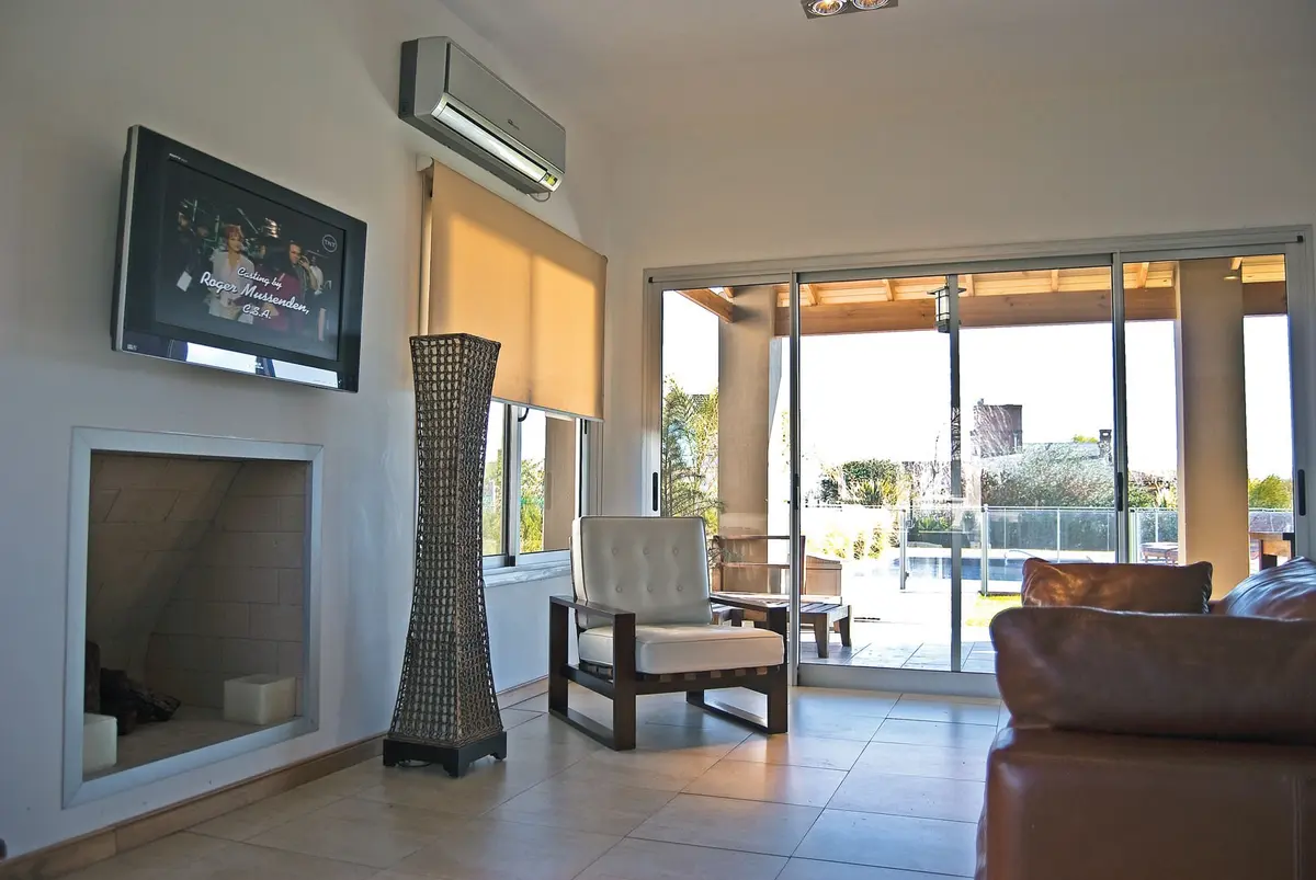 Living moderno con ventanales y chimenea a la vista — proyecto Casa 5, por Estudio Martínez Nespral