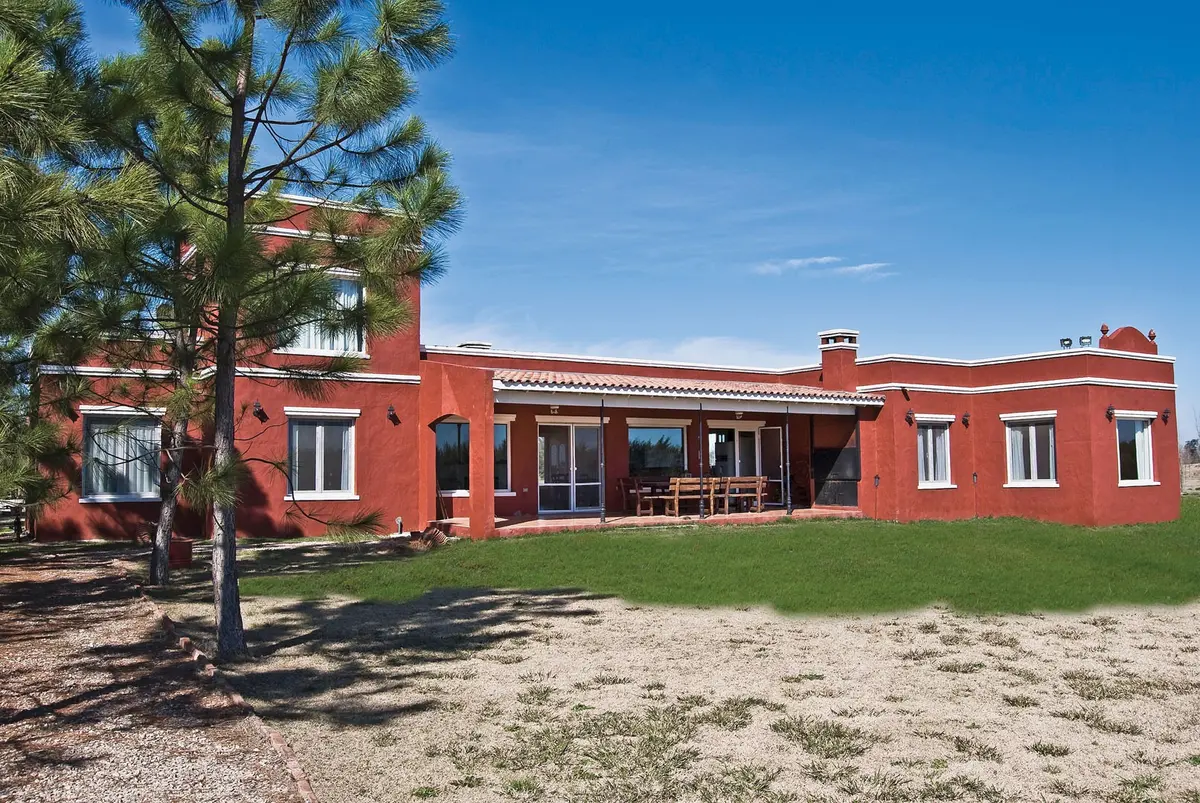 Fachada de casa rural estilo mediterráneo con revoque color bordó — proyecto Casa 4, por Estudio Martínez Nespral