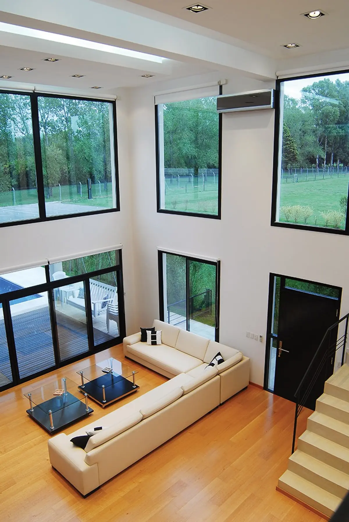 Sala de estar moderna de doble altura com janelas amplas e vista para o campo — projeto Casa 3, por Estudio Martínez Nespral