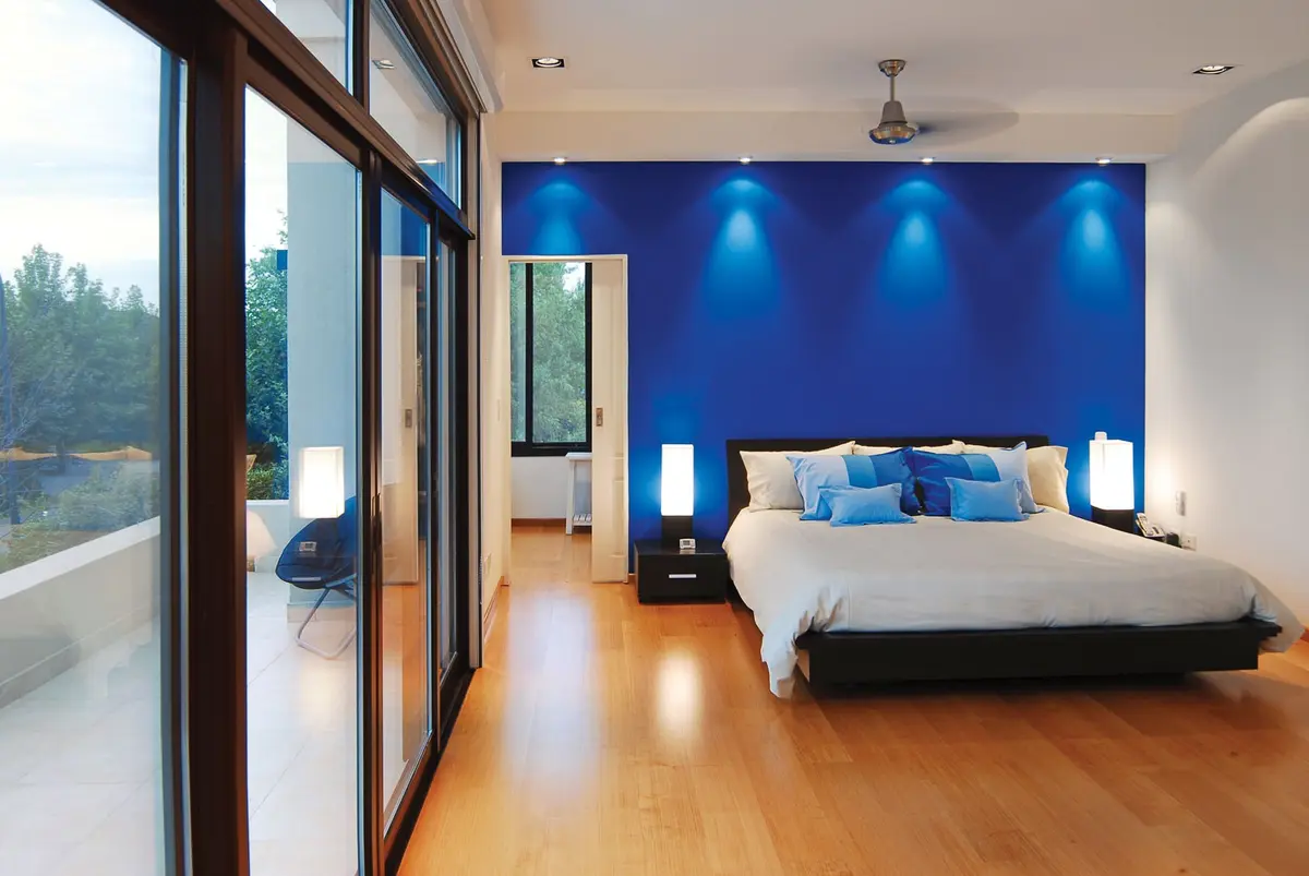 Dormitorio moderno con pared azul vibrante y ventanales amplios — proyecto Casa 3, por Estudio Martínez Nespral