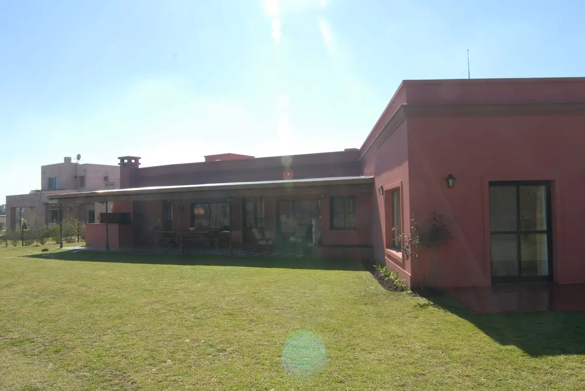 Fachada de casa rural con pérgola y césped verde — proyecto Casa 2, por Estudio Martínez Nespral