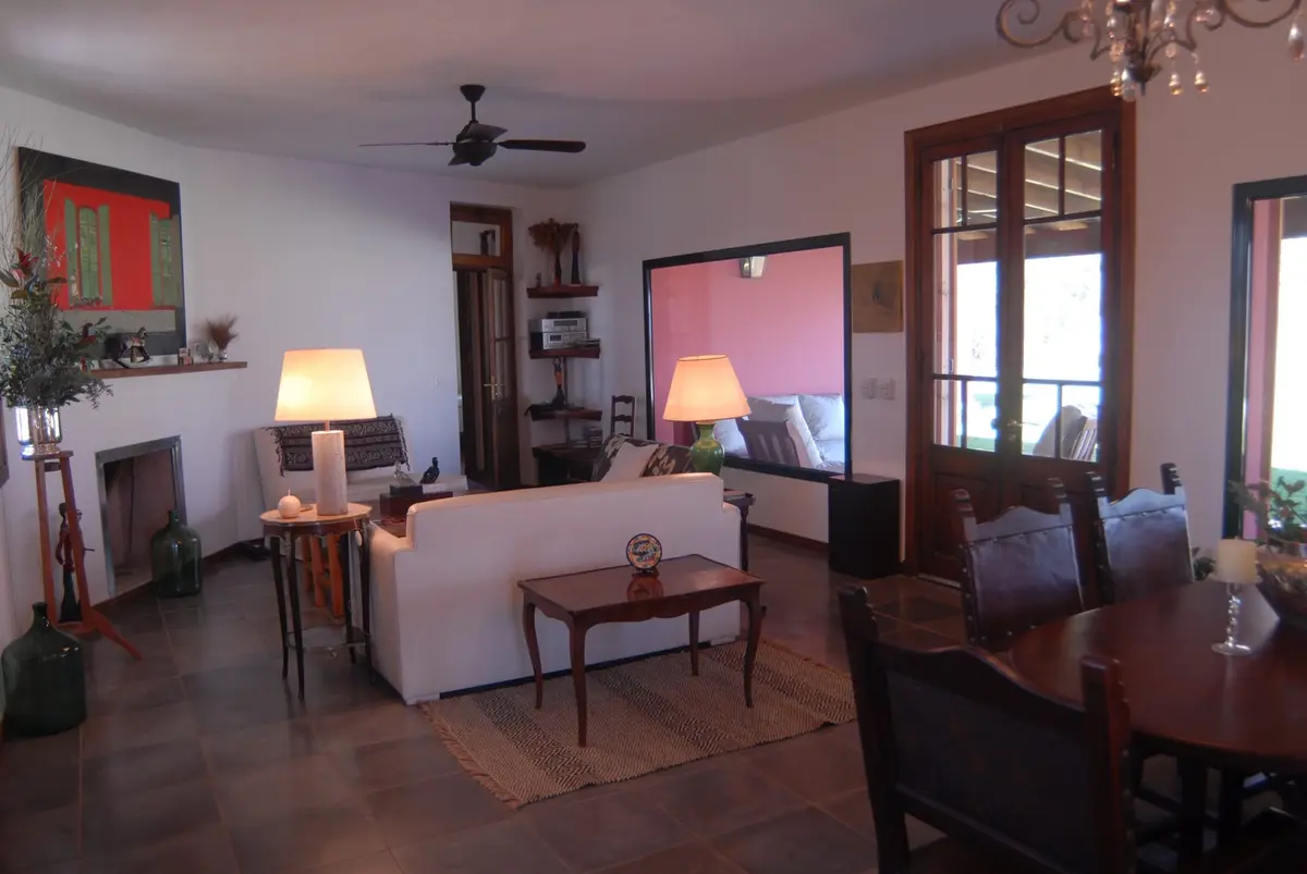 Sala de jantar e estar estilo mediterrâneo com lareira e obra de arte — projeto Casa 2, por Estudio Martínez Nespral