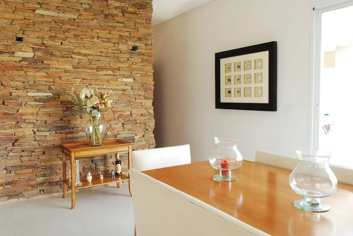 Comedor moderno con pared de piedra y mesa de madera — proyecto Casa 1, por Estudio Martínez Nespral