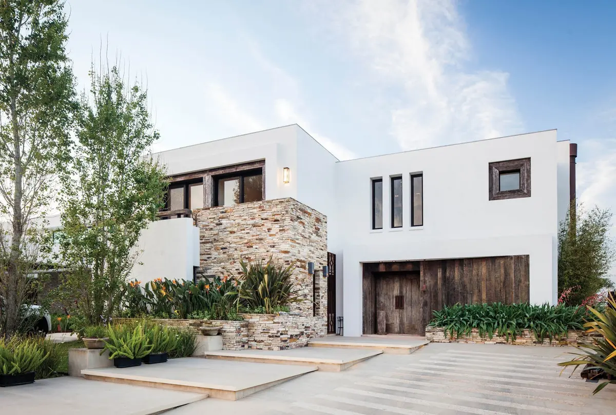 Fachada moderna con contraste de piedra y madera, amplias ventanas — proyecto Casa DFS, por Estudio Gamboa