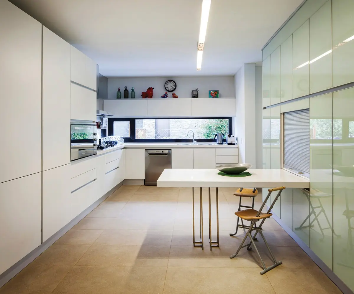 Cozinha moderna minimalista com ilha e parede de vidro verde — projeto Casa DFS, por Estudio Gamboa