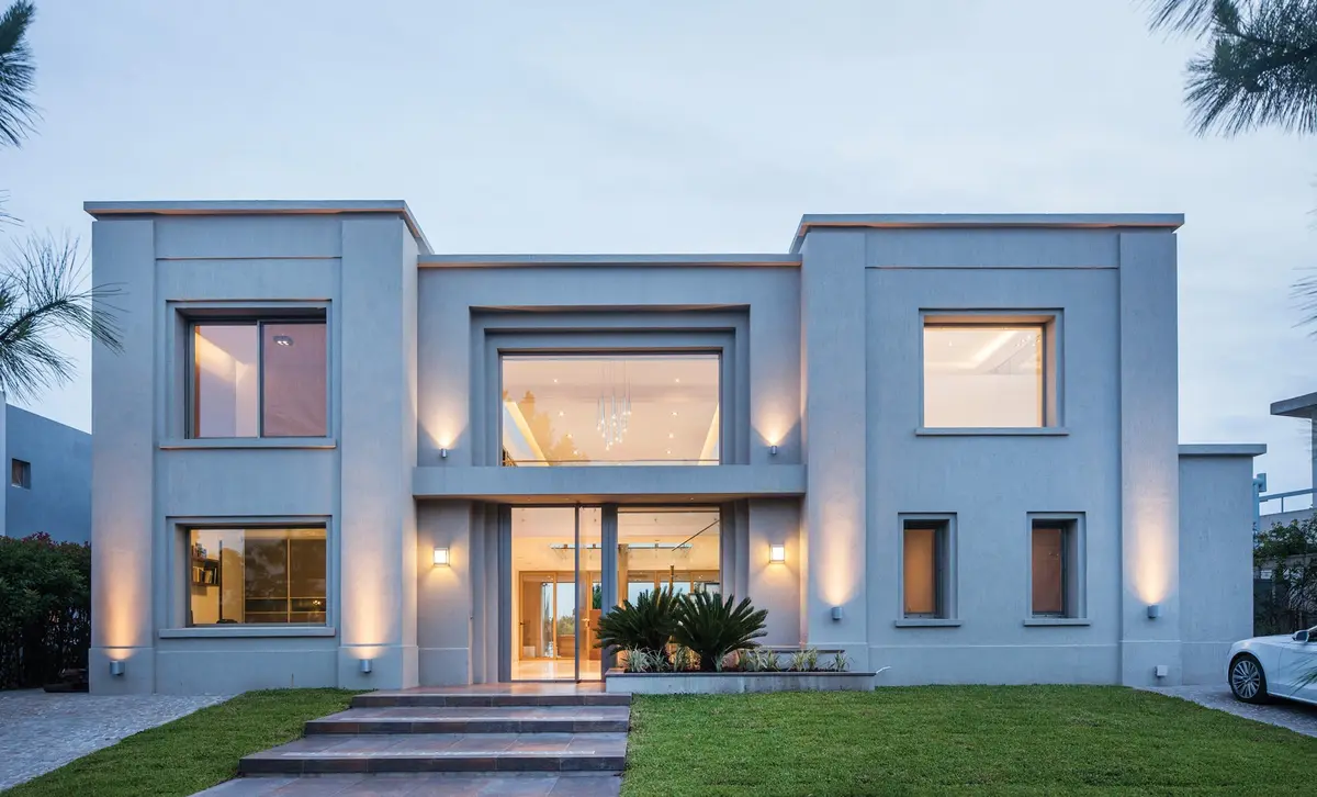 fachada de casa moderna con grandes ventanales y jardin — proyecto Casa MSC, por Estudio Gamboa