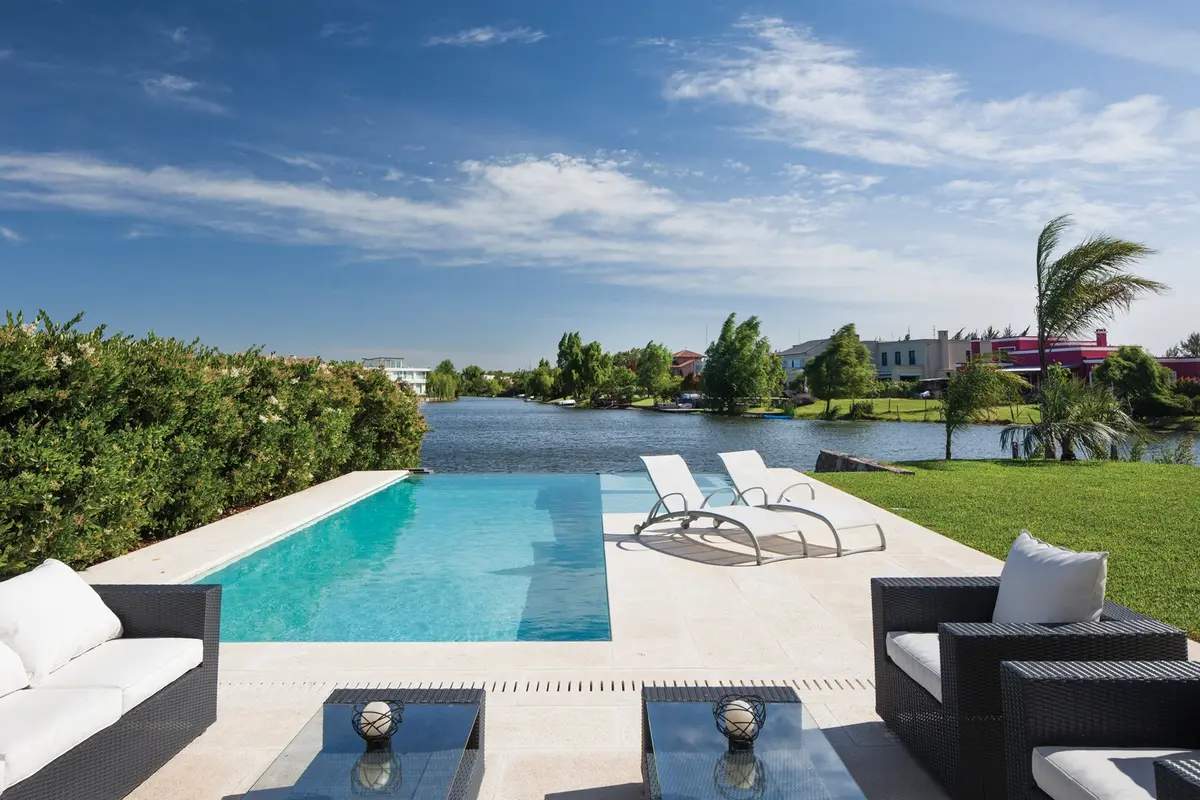 Quincho moderno con piscina infinita frente al lago — proyecto Casa MSC, por Estudio Gamboa
