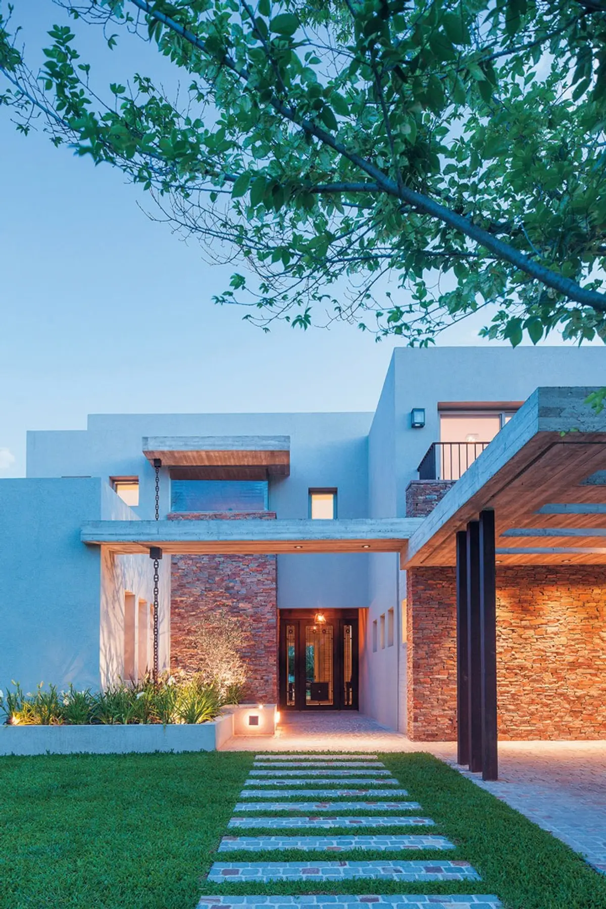 Fachada moderna com pedra, pergolado de madeira e caminho de lajes — projeto Casa CSZ, por Estudio Gamboa
