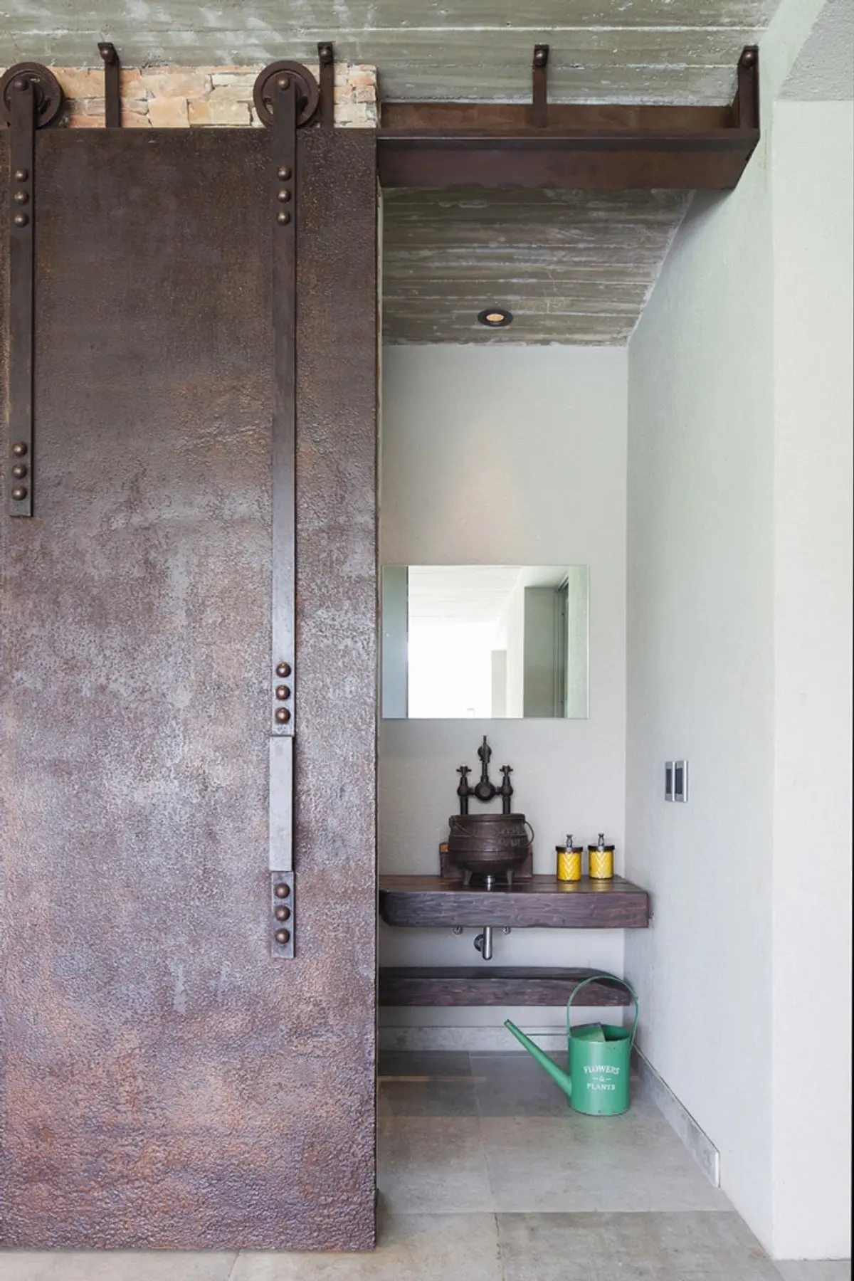 Baño industrial con puerta corrediza de metal y bacha de piedra — proyecto Casa CSZ, por Estudio Gamboa