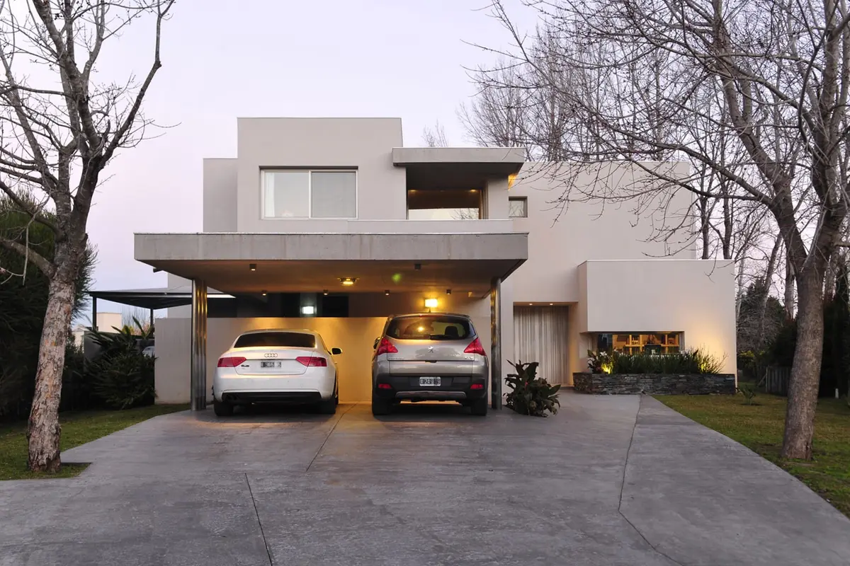Casa moderna con fachada de hormigón blanco y grandes ventanales — proyecto Casa GGG, por Estudio Gamboa