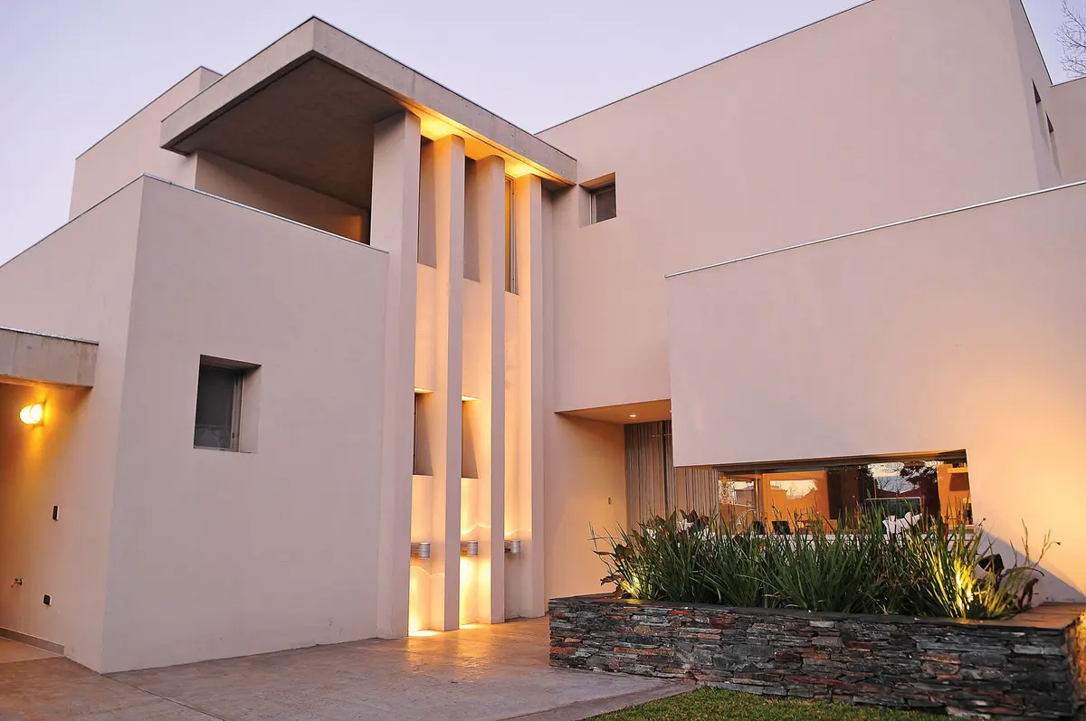 Fachada moderna con iluminación integrada al atardecer — proyecto Casa GGG, por Estudio Gamboa