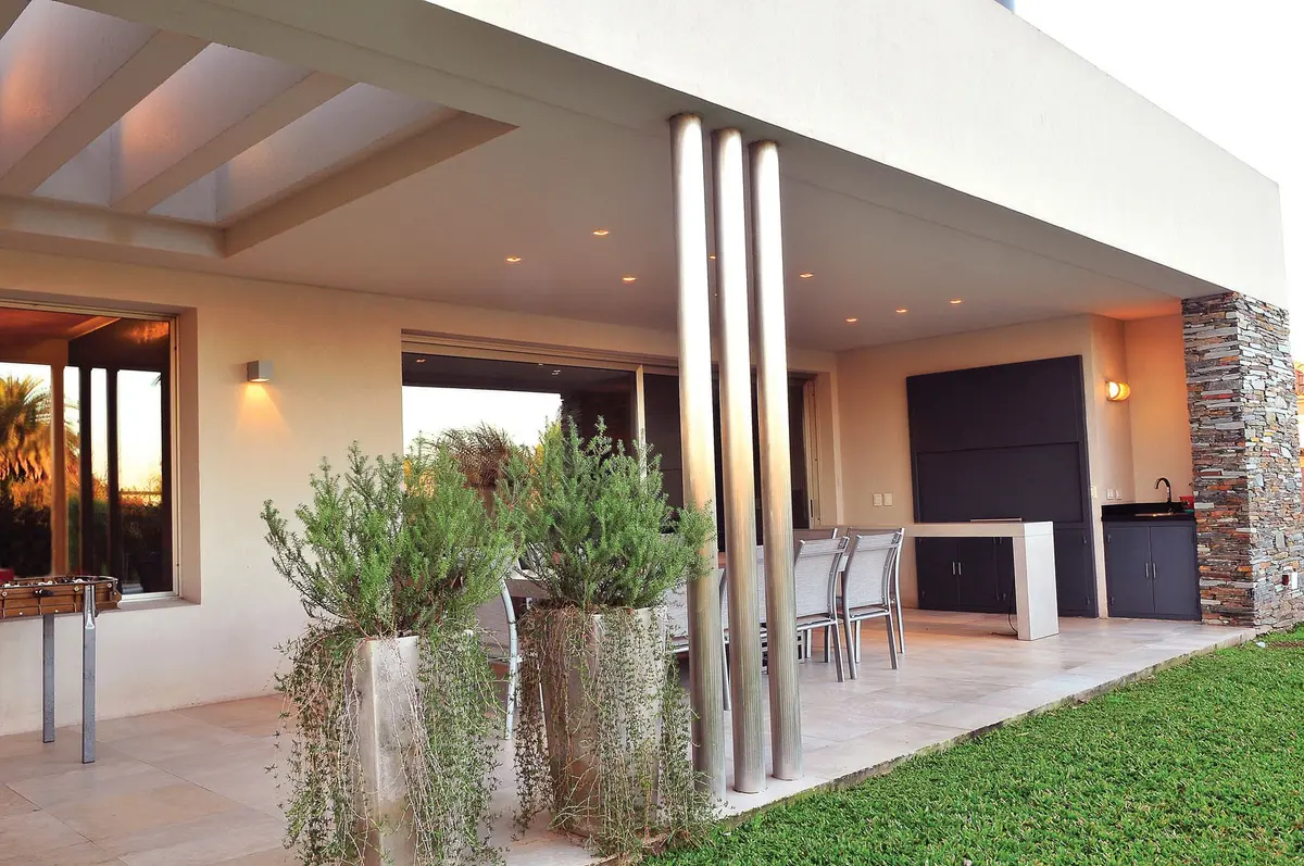 Pátio moderno com pergolado e plantas pendentes — projeto Casa GGG, por Estudio Gamboa