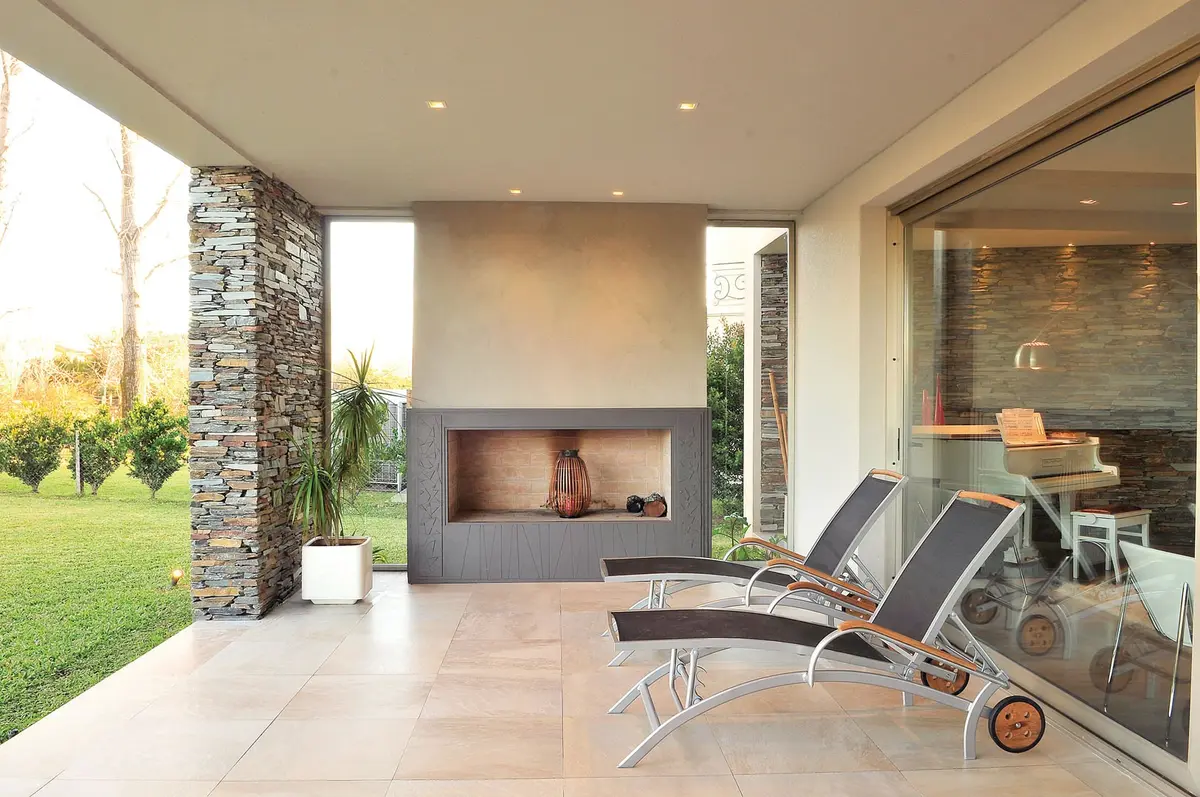 Área de patio moderna com lareira e móveis de exterior — projeto Casa GGG, por Estudio Gamboa