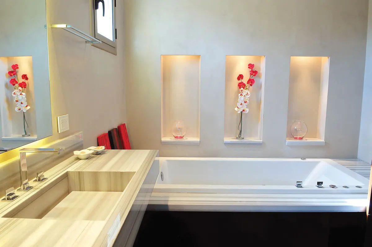 banheiro moderno com nichos iluminados e banheira freestanding — projeto Casa GGG, por Estudio Gamboa