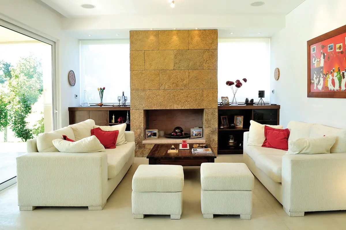 Sala moderna com lareira de pedra e sofás brancos — projeto Casa GTT, por Estudio Gamboa