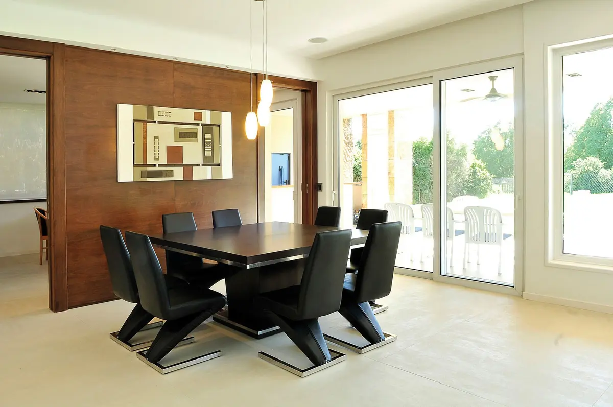Sala de jantar moderna com mesa de madeira escura e cadeiras pretas — projeto Casa GTT, por Estudio Gamboa