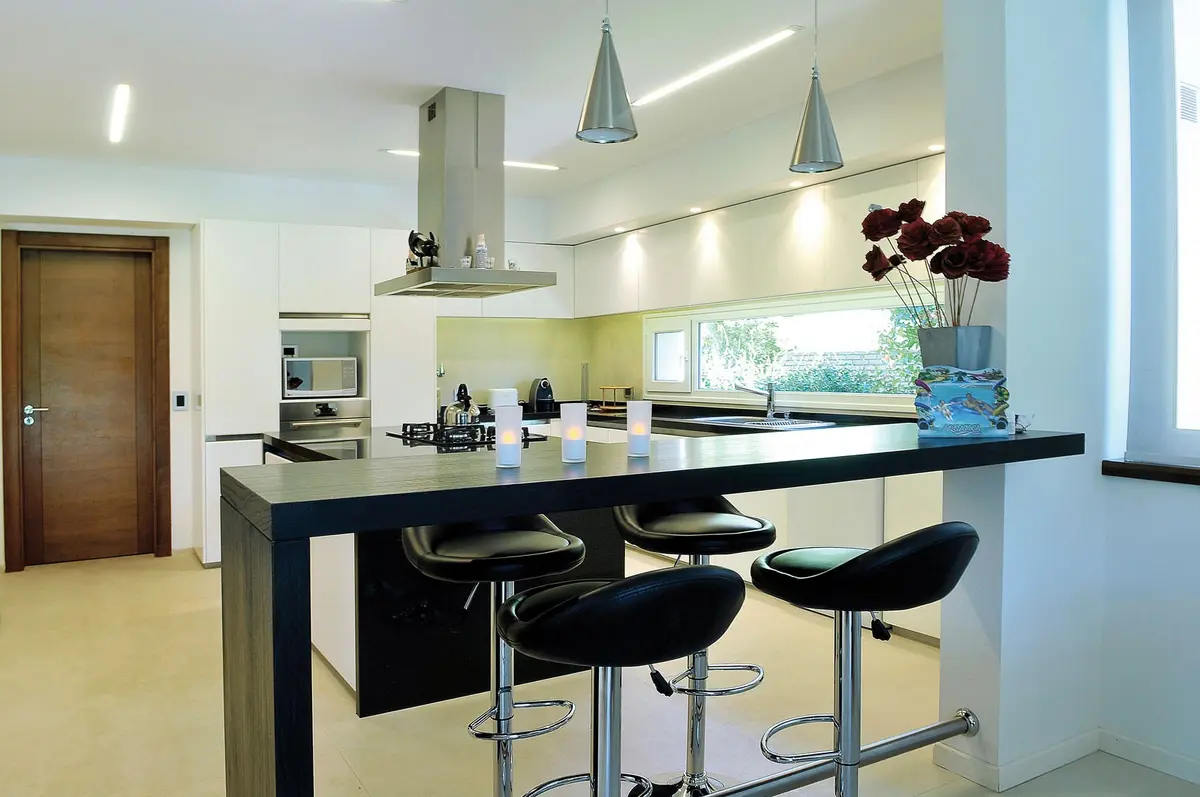 Cozinha moderna com ilha de mármore e bancos altos — projeto Casa GTT, por Estudio Gamboa